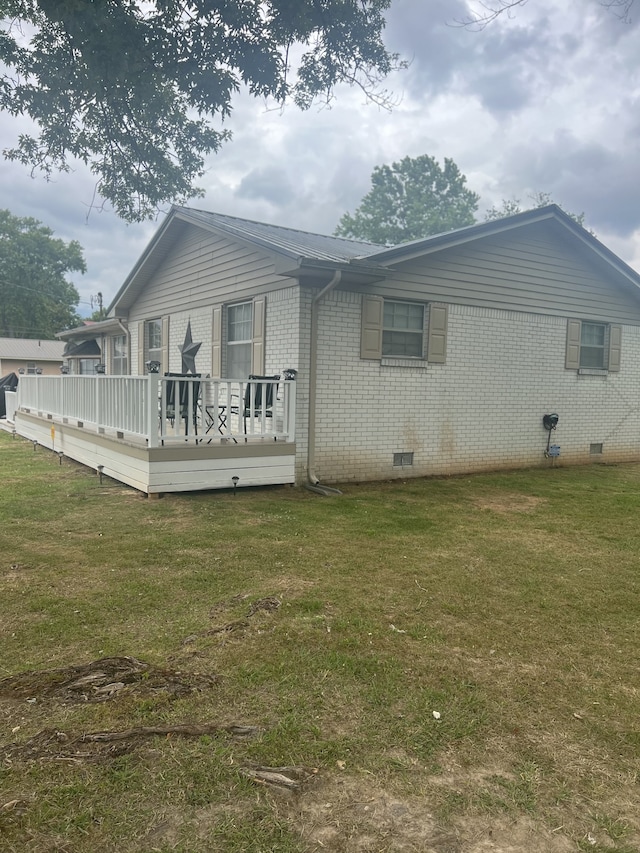 back of house featuring a deck and a yard