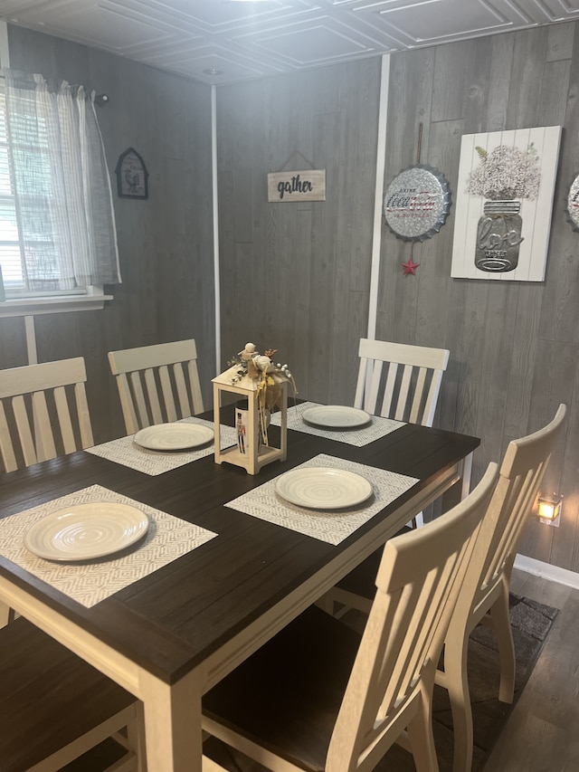 dining area featuring wooden walls and wood-type flooring