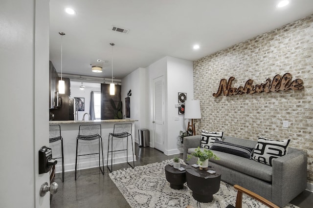 living room featuring sink and brick wall