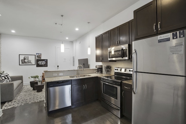 kitchen with decorative backsplash, appliances with stainless steel finishes, kitchen peninsula, dark brown cabinetry, and sink