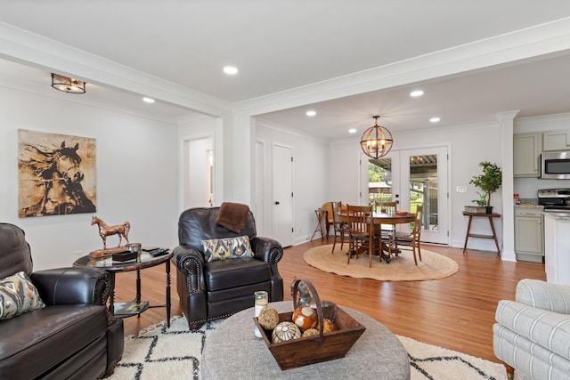 living area with recessed lighting, light wood-type flooring, and ornamental molding