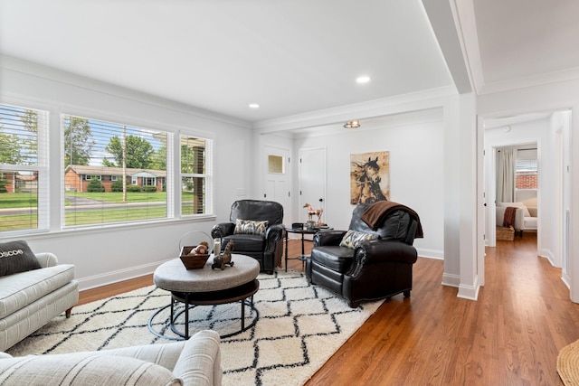 living room featuring recessed lighting, ornamental molding, baseboards, and wood finished floors