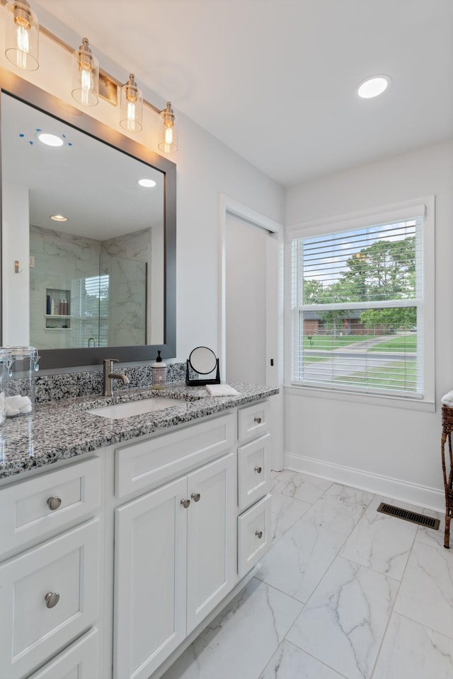 full bath featuring a marble finish shower, visible vents, baseboards, marble finish floor, and vanity