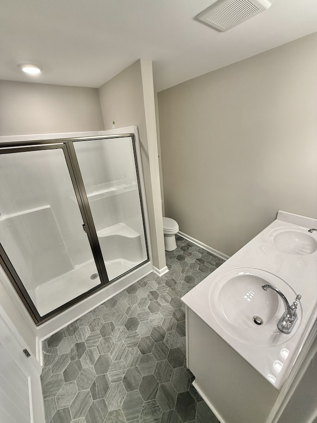 bathroom with a shower with door, vanity, and toilet