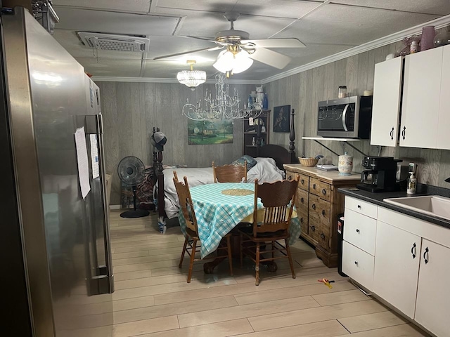 kitchen with visible vents, crown molding, stainless steel appliances, dark countertops, and a sink