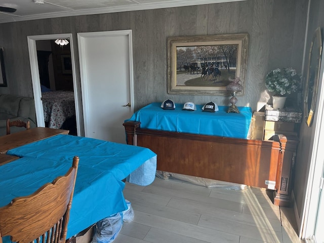 bedroom with ornamental molding and wood finished floors