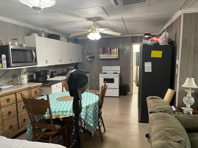 kitchen featuring freestanding refrigerator, white electric range oven, stainless steel microwave, visible vents, and light wood-style floors