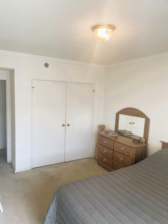 bedroom with carpet floors, a closet, ornamental molding, and a textured ceiling