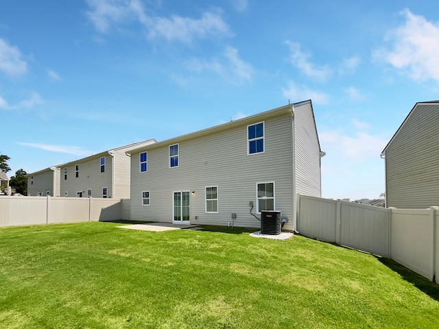 rear view of house featuring a lawn, central air condition unit, and a patio area