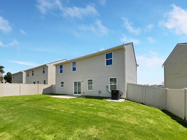 back of property with a yard, a patio area, and central air condition unit