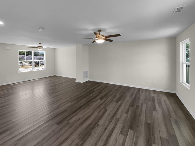 empty room with ceiling fan and dark hardwood / wood-style flooring