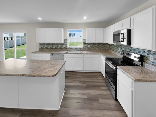 kitchen with appliances with stainless steel finishes, tasteful backsplash, dark hardwood / wood-style flooring, and white cabinetry