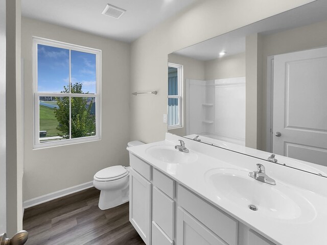 bathroom with dual vanity, wood-type flooring, and toilet