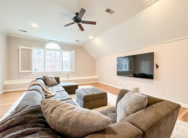 living room with vaulted ceiling, ornamental molding, ceiling fan, and light wood-type flooring