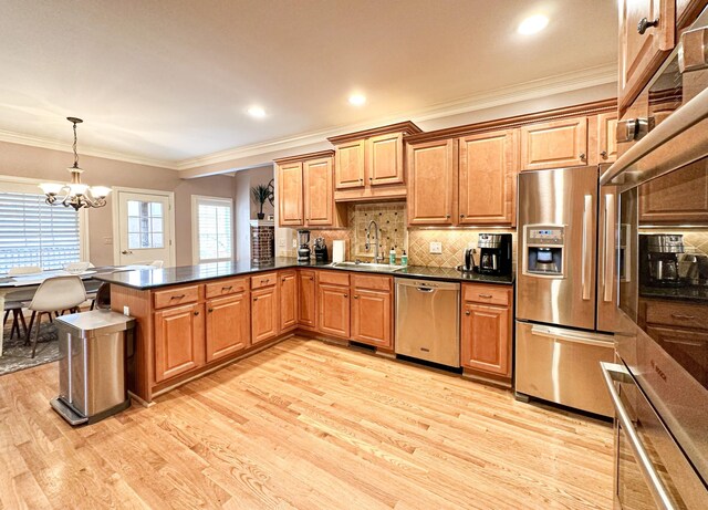 kitchen featuring light wood-type flooring, sink, stainless steel appliances, and kitchen peninsula