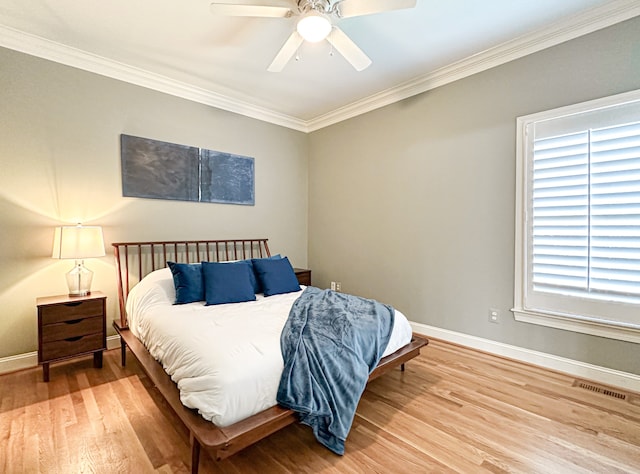 bedroom featuring ceiling fan, light wood-type flooring, multiple windows, and crown molding