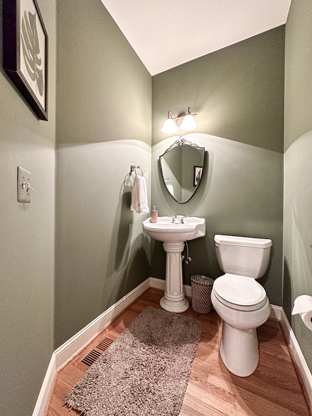 bathroom with wood-type flooring and toilet