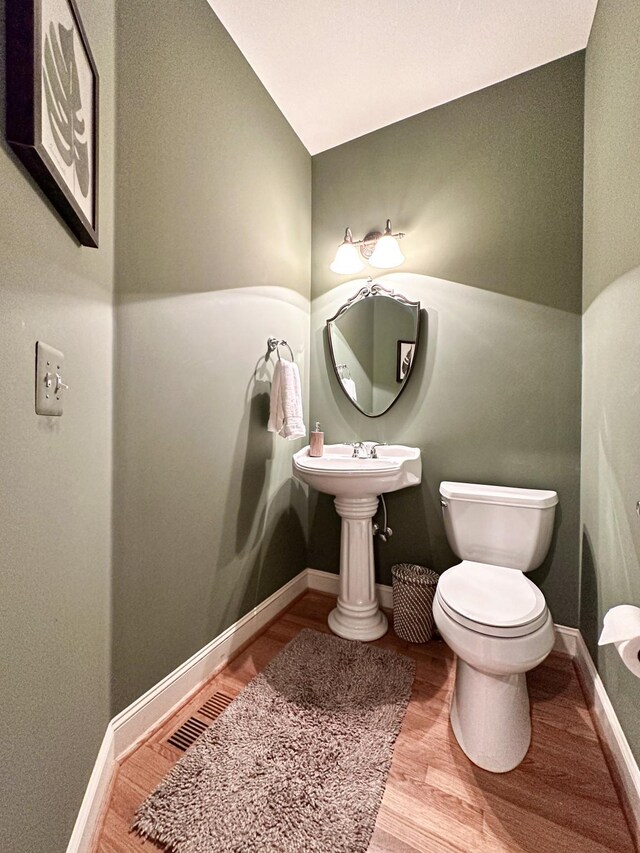 bathroom with hardwood / wood-style floors and toilet