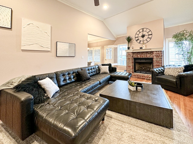 living room featuring a fireplace, lofted ceiling, ornamental molding, and hardwood / wood-style flooring