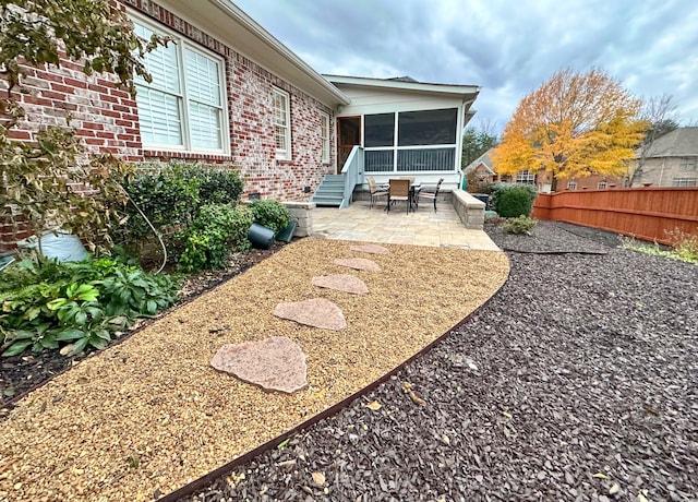 view of yard with a sunroom and a patio area