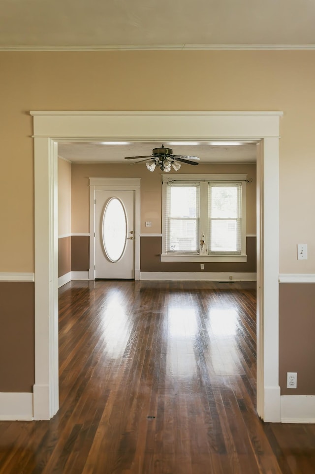 interior space featuring ornamental molding, dark wood-type flooring, and ceiling fan