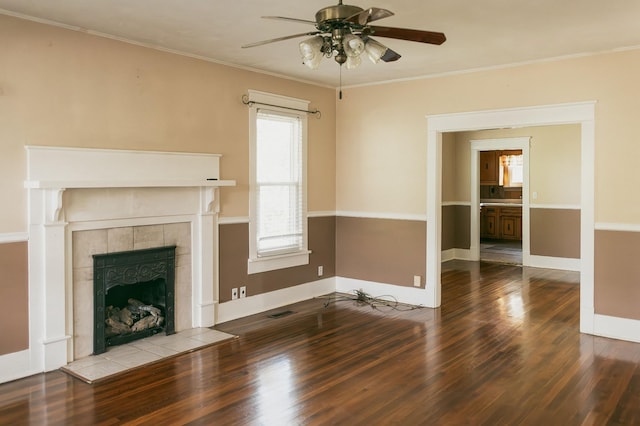 unfurnished living room featuring a fireplace, crown molding, wood-type flooring, and ceiling fan