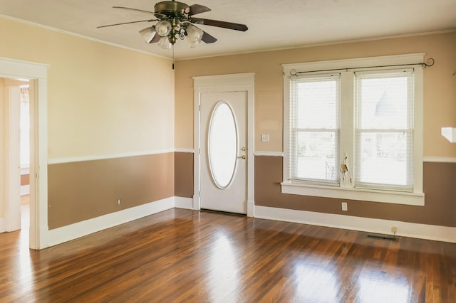 foyer with dark wood-type flooring, ornamental molding, and ceiling fan