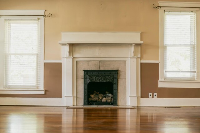 details featuring hardwood / wood-style floors and a tile fireplace