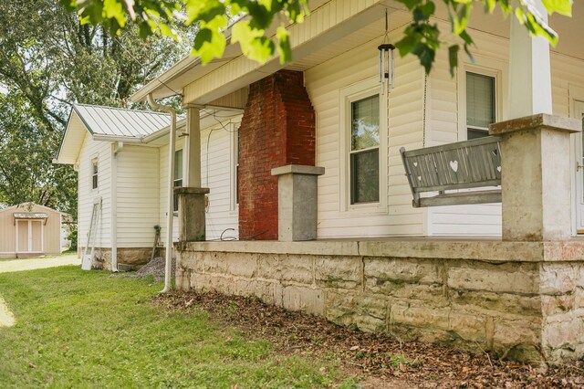 view of side of property with a storage shed and a yard