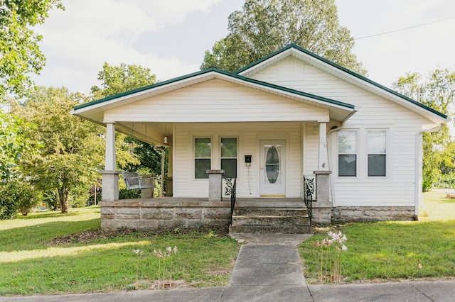 bungalow with a front lawn and covered porch