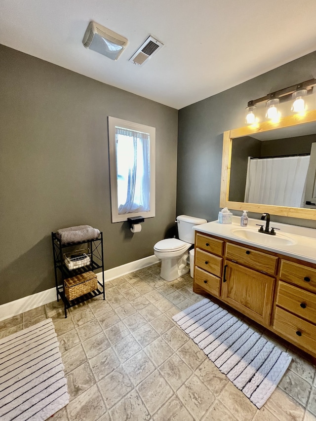 bathroom featuring vanity, toilet, and tile patterned flooring