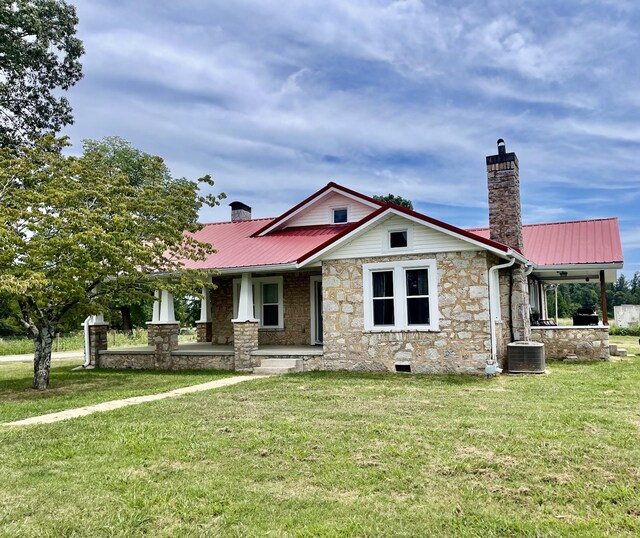 view of front of property with central AC and a front lawn