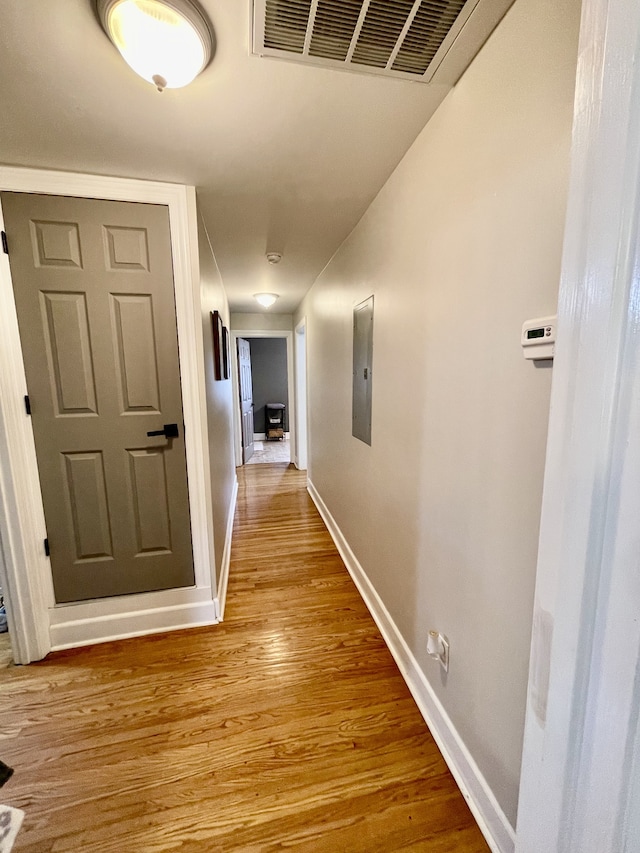 corridor featuring electric panel and light hardwood / wood-style floors