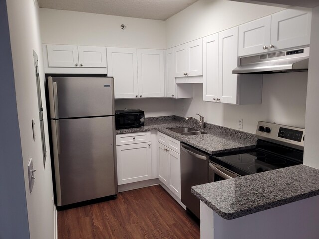 kitchen featuring stainless steel appliances, dark hardwood / wood-style flooring, white cabinets, sink, and kitchen peninsula