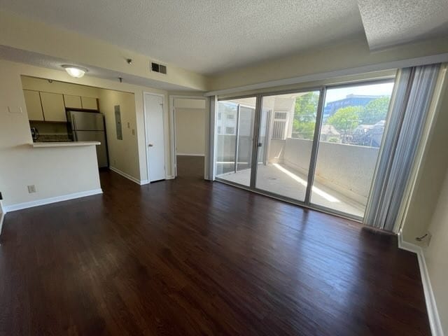 unfurnished living room featuring dark hardwood / wood-style floors and a textured ceiling