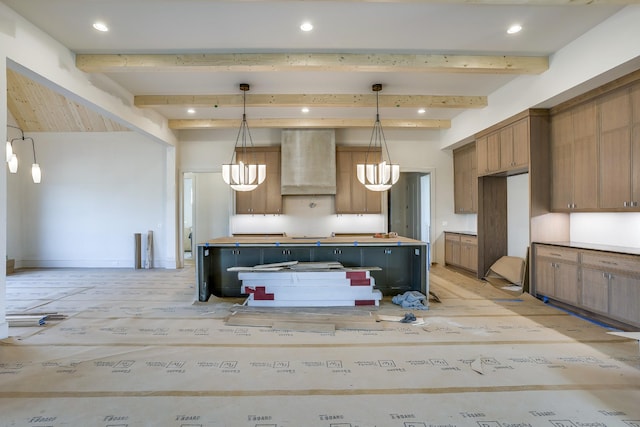 kitchen with hanging light fixtures, beamed ceiling, light hardwood / wood-style floors, and wall chimney exhaust hood