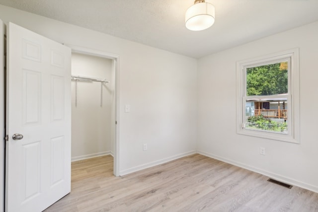 unfurnished bedroom with a closet and light hardwood / wood-style floors