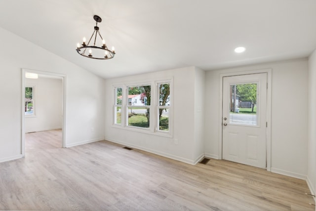 entryway with light hardwood / wood-style flooring, vaulted ceiling, a chandelier, and a wealth of natural light