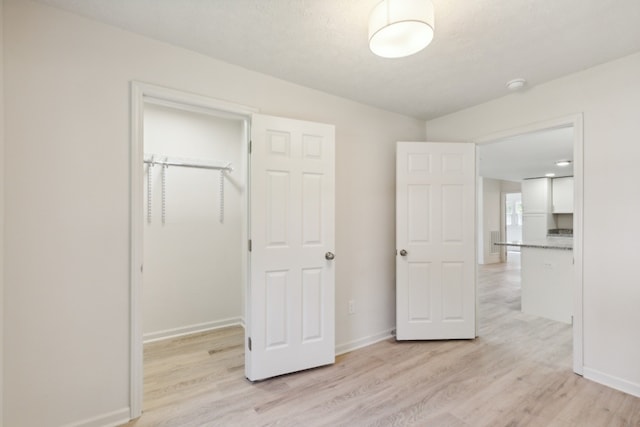 unfurnished bedroom with light hardwood / wood-style flooring and a closet