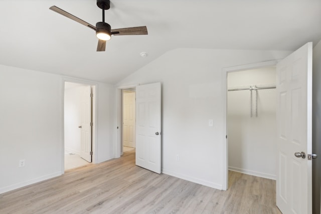 unfurnished bedroom with ceiling fan, a closet, lofted ceiling, and light hardwood / wood-style floors