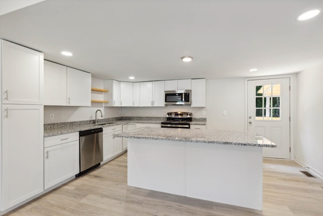 kitchen featuring light wood-type flooring, appliances with stainless steel finishes, and white cabinets