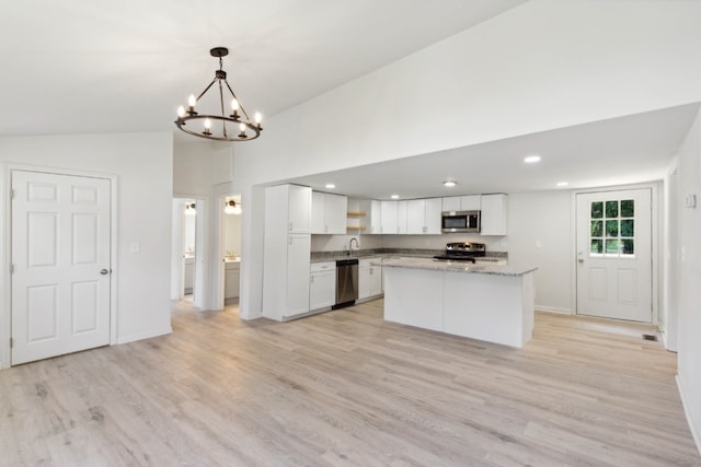 kitchen with light wood-type flooring, a notable chandelier, lofted ceiling, stainless steel appliances, and white cabinets