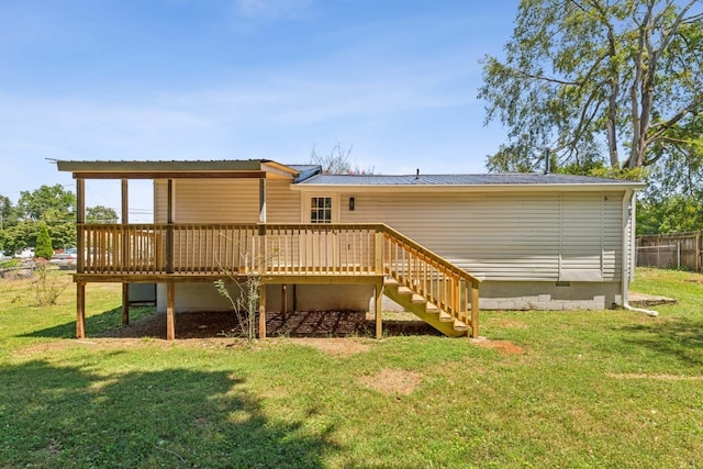 rear view of property with a lawn and a deck