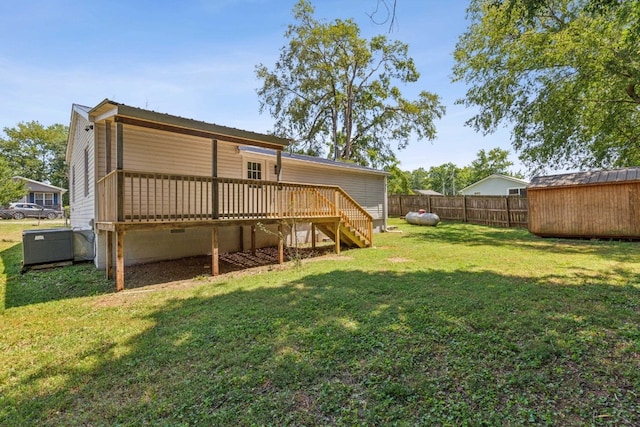 back of property featuring a wooden deck and a lawn