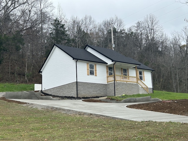 view of front of home featuring covered porch and a front lawn