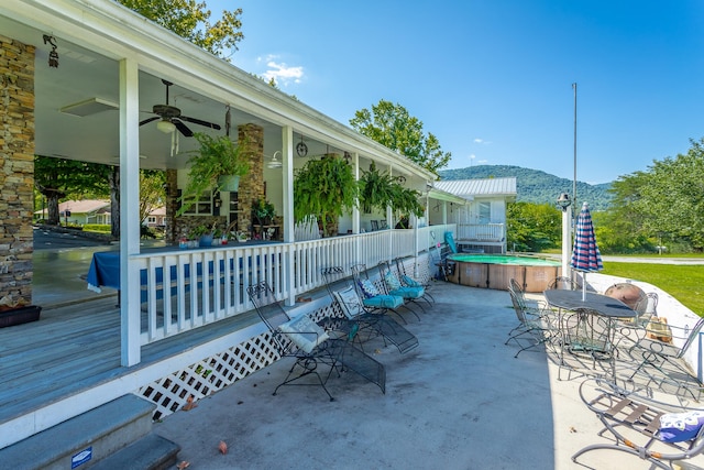 view of patio / terrace featuring a mountain view, a hot tub, and ceiling fan