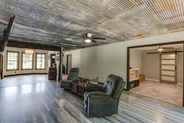 interior space featuring hardwood / wood-style flooring, a barn door, and ceiling fan