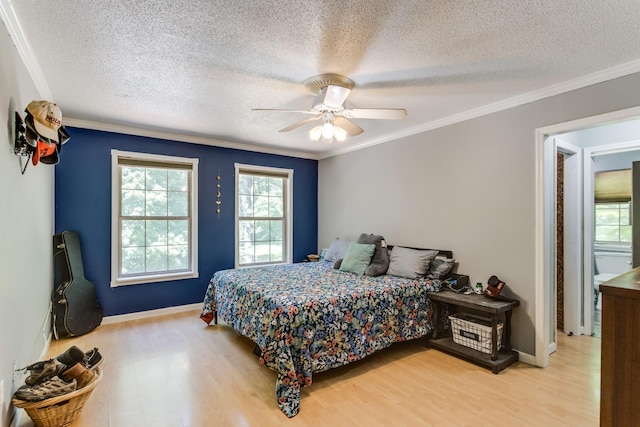 bedroom with a textured ceiling, ornamental molding, ceiling fan, and light wood-type flooring