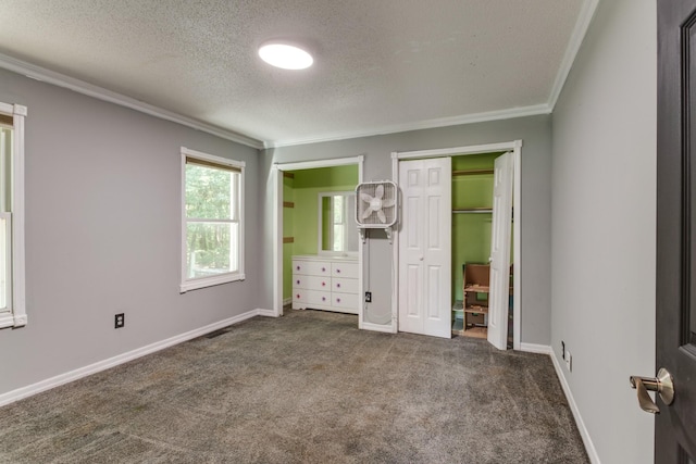 unfurnished bedroom featuring a closet, ornamental molding, dark carpet, and a textured ceiling