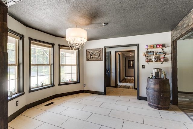 unfurnished dining area with light tile patterned floors, a textured ceiling, and a chandelier